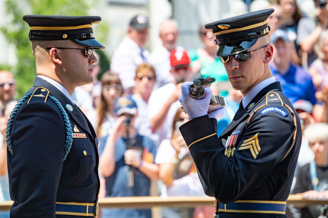 Two soldiers facing each other while one holds a weapon at his shoulders.