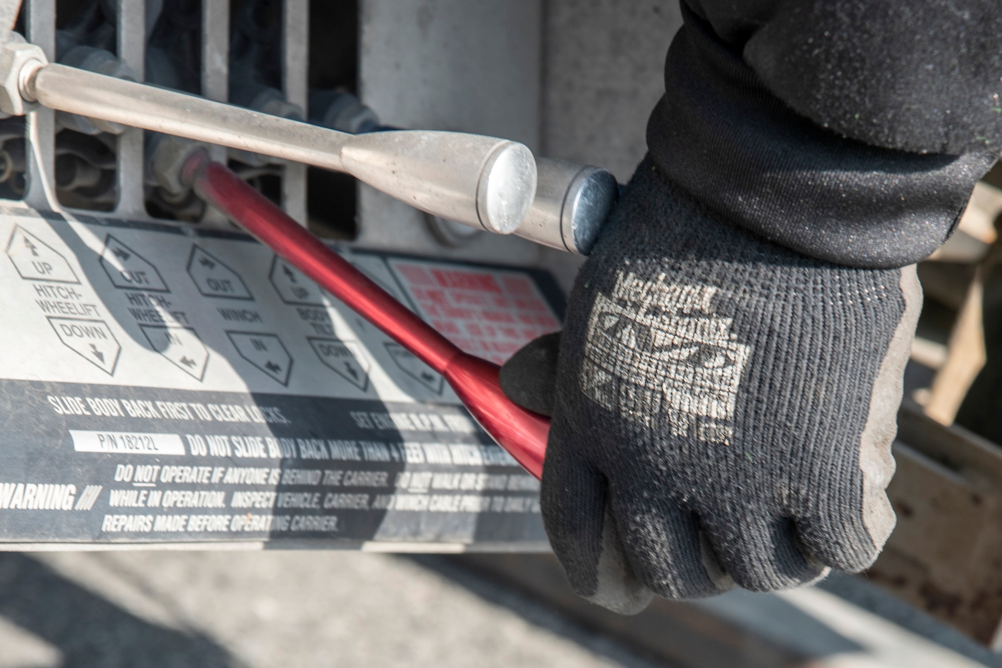 Jonathan Mejia, owner of JT Towing LLC, operates a lever on a tow truck July 1, 2019, on Joint Base Elmendorf-Richardson, Alaska. Abandoned and illegally parked vehicles on Joint Base Elmendorf-Richardson, Alaska, are towed because they present safety hazards.