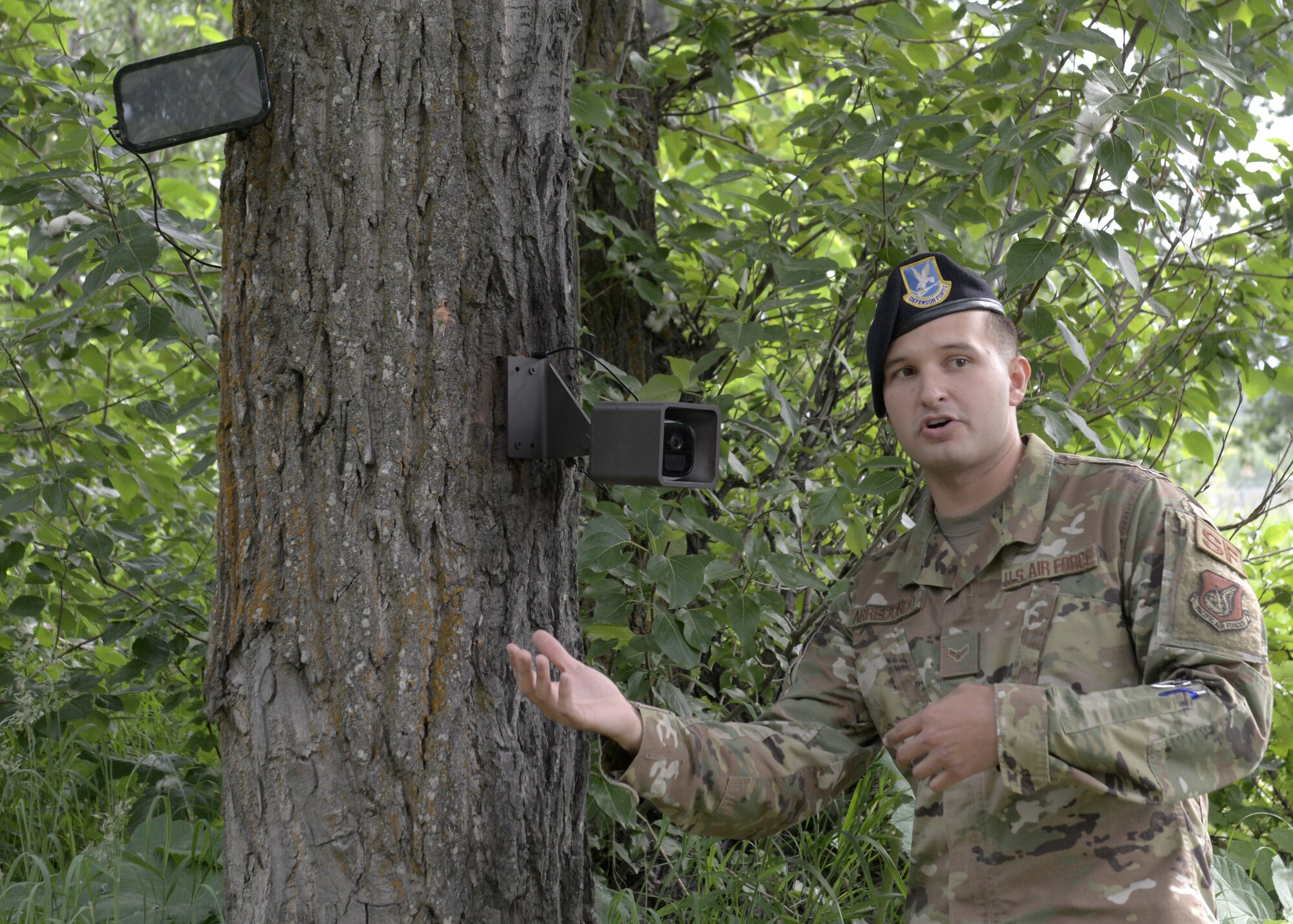 U.S. Air Force Airman 1st Class Stefan Arredondo, a 673d Air Base Wing Arctic Spark Council marketing and networking assistant, discuss a camera’s impact on Joint Base Elmendorf-Richardson’s mission during a high-definition, two-way camera unveiling near a wildlife access point on Joint Base Elmendorf-Richardson, Alaska, July, 2, 2019. The unveiling of the cameras was a result of an MD5 workshop focused on the commander’s priority of improving gate security and efficiency. The cameras were installed to prevent unauthorized entry onto the installation. (U.S. Air Force photo by Airman 1st Class Emily Farnsworth)