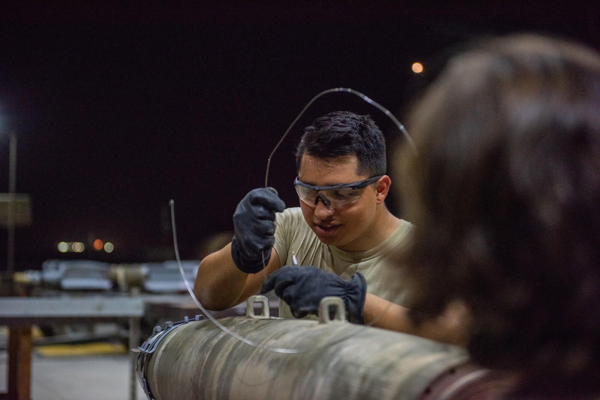Airman 1st Class Giovanni Escutia, 380th Expeditionary Maintenance Squadron conventional maintenance technician, pulls a fuse to the middle of a GBU-38 June 21, 2019, at Al Dhafra Air Base, United Arab Emirates.