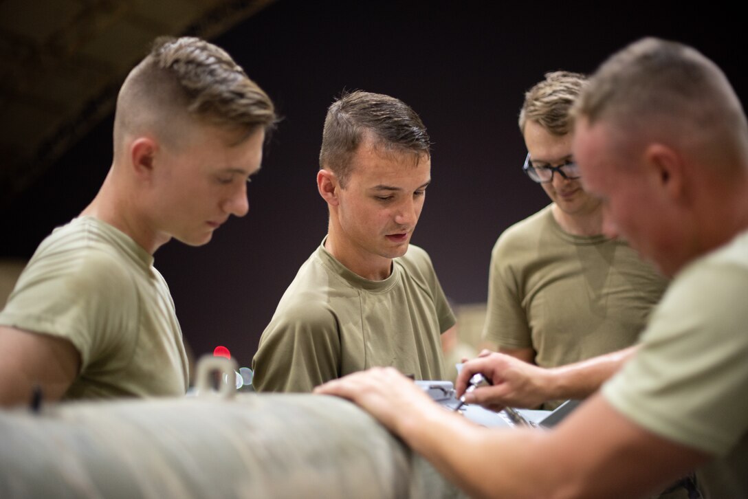 Airmen of the 380th Expeditionary Maintenance Squadron attach a tail fin to a GBU-38 June 21, 2019, at Al Dhafra Air Base, United Arab Emirates.