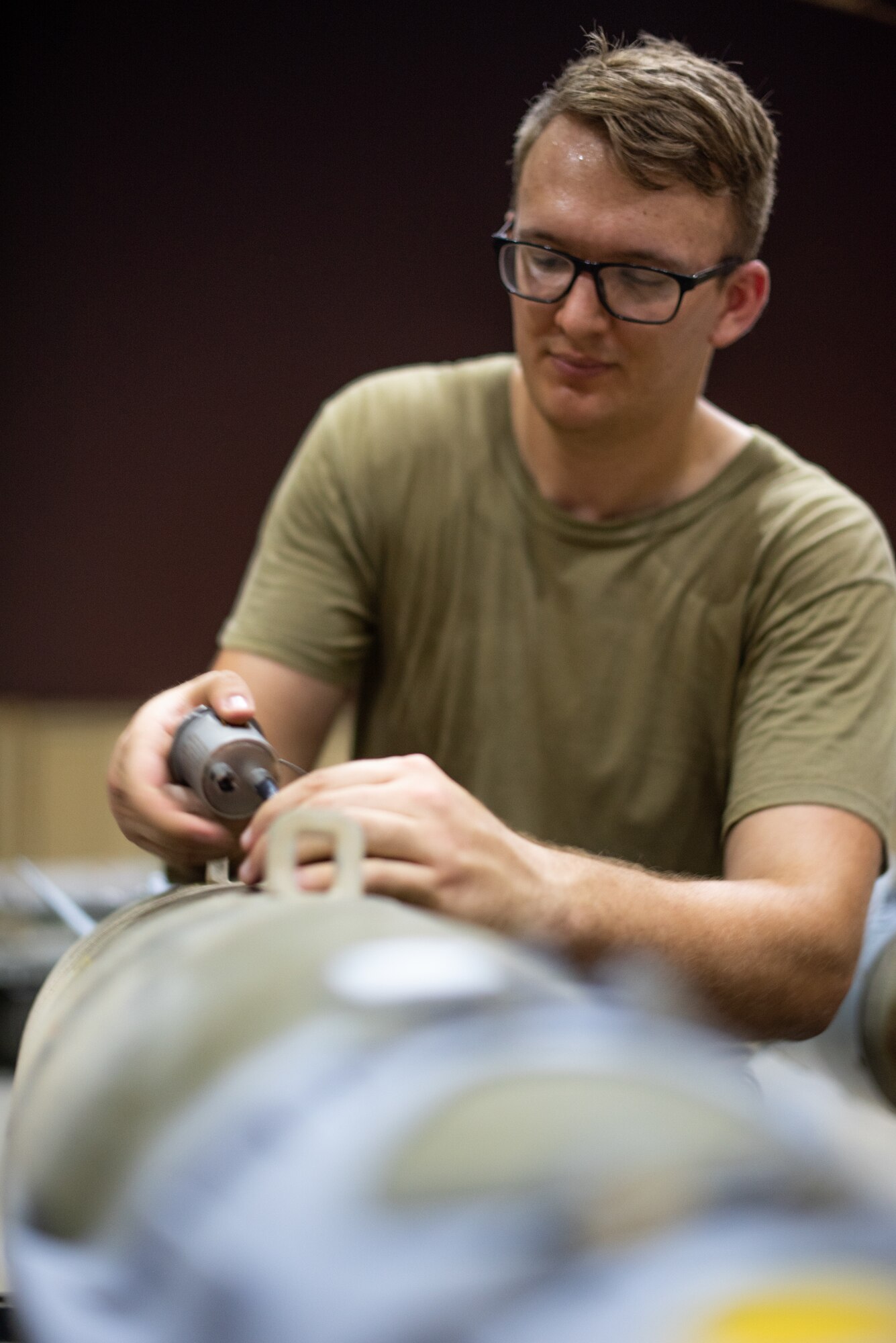 Staff Sgt. Kyle Poston, 380th Expeditionary Maintenance Squadron conventional maintenance crew chief, attaches a fuse to the ignitor on a GBU-38 June 21, 2019, at Al Dhafra Air Base, United Arab Emirates.