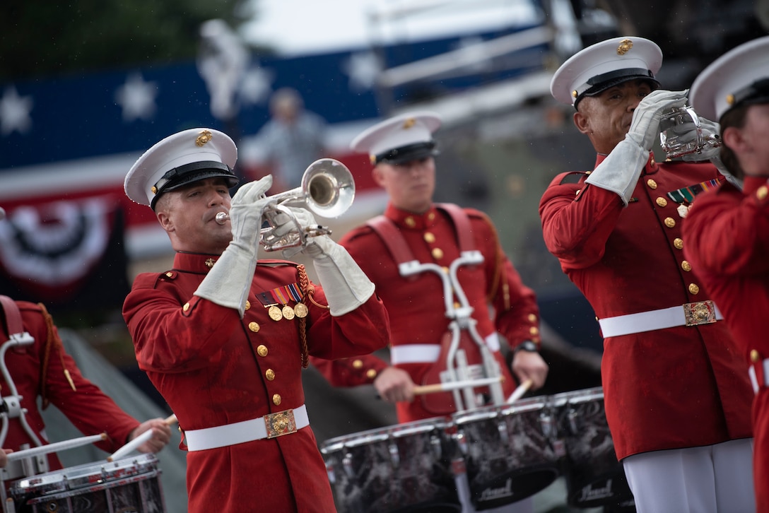 A marine in a red uniform plays a trumpet.