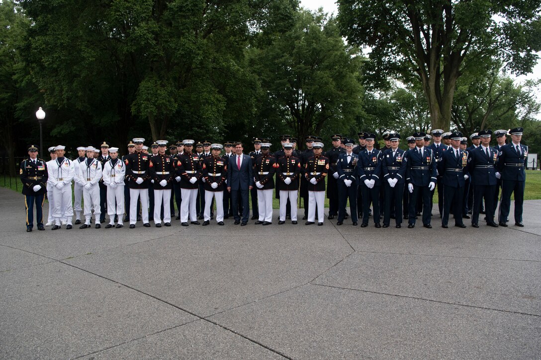 Acting Defense Secretary Dr. Mark T. Esper stands with a group of service members.