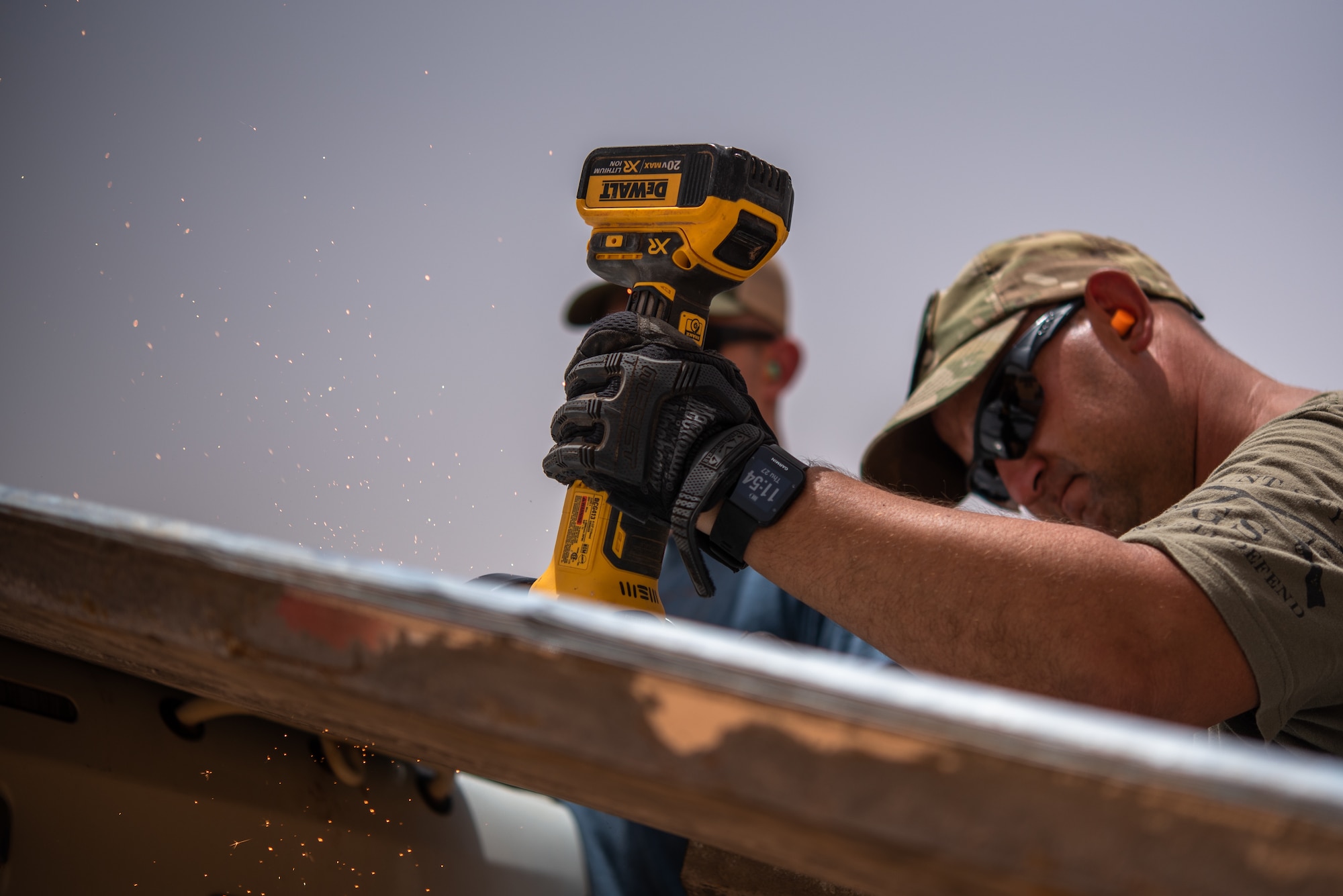 U.S. Air Force Tech. Sgt. Kelly Warren, 724th Expeditionary Air Base Squadron civil engineer flight structural craftsman, cuts a sheet of tin roofing at a village in Agadez, Niger, June 27, 2019. The civil engineer Airmen installed the tin roof on a classroom they built for the local Nigeriens. (U.S. Air Force photo by Staff Sgt. Devin Boyer)