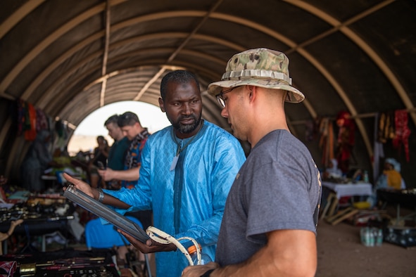 A vendor sells souvenirs to a U.S. service member assigned to Nigerien Air Base 201 during a bazaar at the base in Agadez, Niger, June 30, 2019. The bazaar gives local Nigeriens a chance to sell their products so they can help their villages while strengthening the relationship with the military community.  (U.S. Air Force photo by Staff Sgt. Devin Boyer)