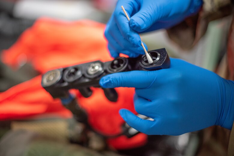 Airman 1st Class Ryan Joplin, 380th Expeditionary Operations Support Squadron aircrew flight equipment technician, cleans a G-suit port connector June 26, 2019, at Al Dhafra Air Base, United Arab Emirates.