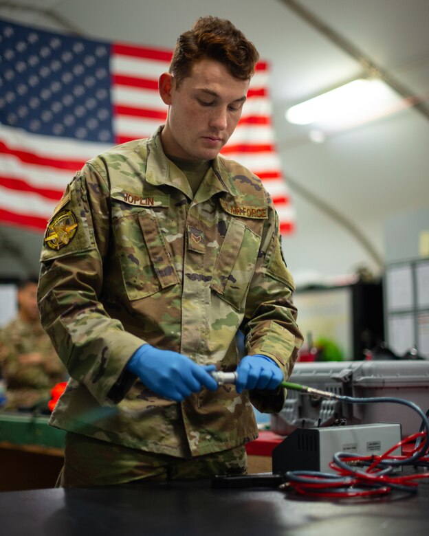 Airman 1st Class Ryan Joplin, 380th Expeditionary Operations Support Squadron aircrew flight equipment technician, prepares to connect an air hose to a pump to test an F-35A Lightning pilot life preserve unit June 26, 2019, at Al Dhafra Air Base, United Arab Emirates.