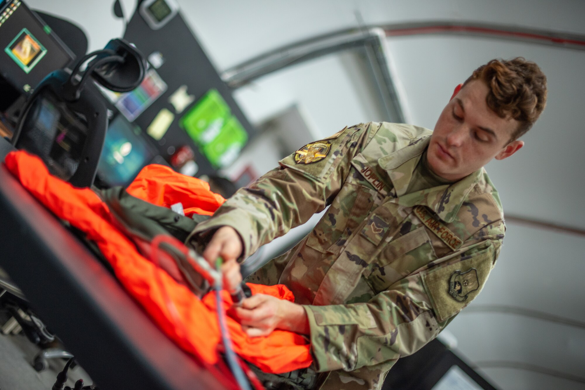 Airman 1st Class Ryan Joplin, 380th Expeditionary Operations Support Squadron aircrew flight equipment technician, connects an air hose to a pump to test an F-35A Lightning pilot life preserve unit June 26, 2019, at Al Dhafra Air Base, United Arab Emirates.