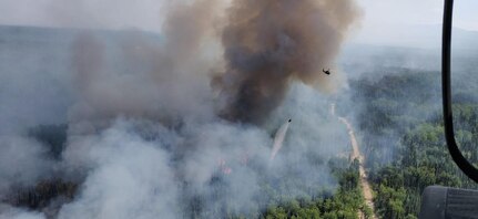 Two Alaska Army National Guard UH-60 Black Hawk helicopters and aircrew from 1st Battalion, 297th Aviation perform Bambi bucket water drops over the Montana Creek Fire, July 4, 2019.