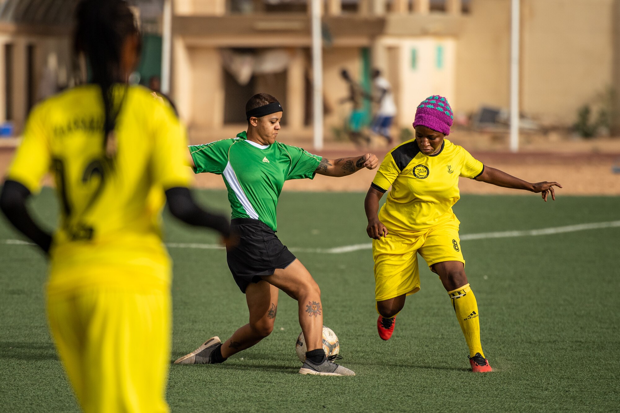 U.S. Air Force Senior Airman Lexis French, 724th Expeditionary Air Base Squadron services flight member, dribbles a soccer ball down a field during a recreational game between Nigerien Air Base 201 and the Nassara Athletic Club Women’s Soccer Team at the Agadez Sports Stadium in Agadez, Niger, July 5, 2019. The civil affairs team held the game to build rapport and promote positive sentiment between the local community and AB 201 personnel. (U.S. Air Force photo by Staff Sgt. Devin Boyer)