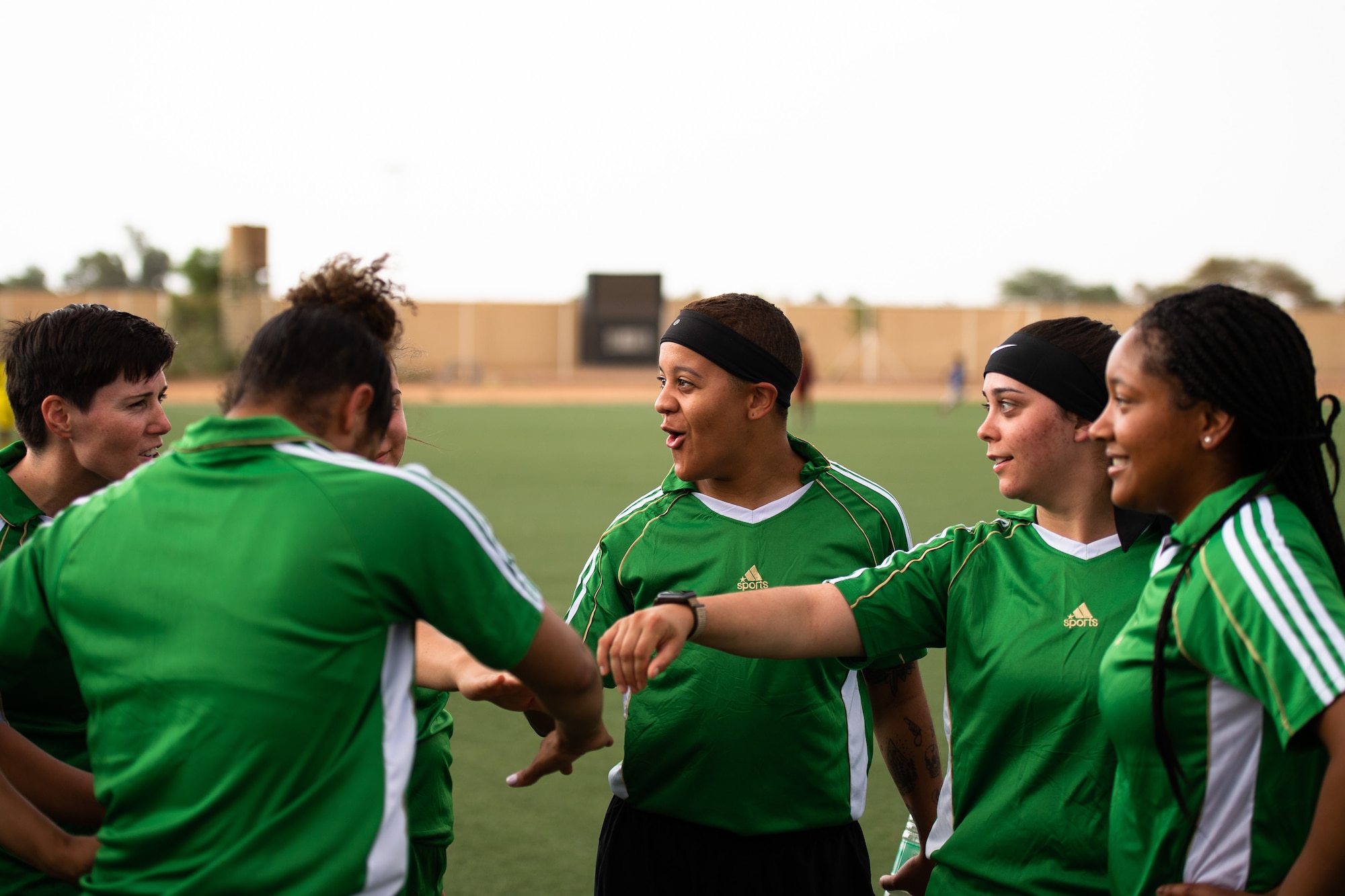 U.S. Air Force Airmen deployed to Nigerien Air Base 201 perform a huddle during a recreational game between Nigerien Air Base 201 and the Nassara Athletic Club Women’s Soccer Team at the Agadez Sports Stadium in Agadez, Niger, July 5, 2019. The civil affairs team held the game to build rapport and promote positive sentiment between the local community and AB 201 personnel. (U.S. Air Force photo by Staff Sgt. Devin Boyer)