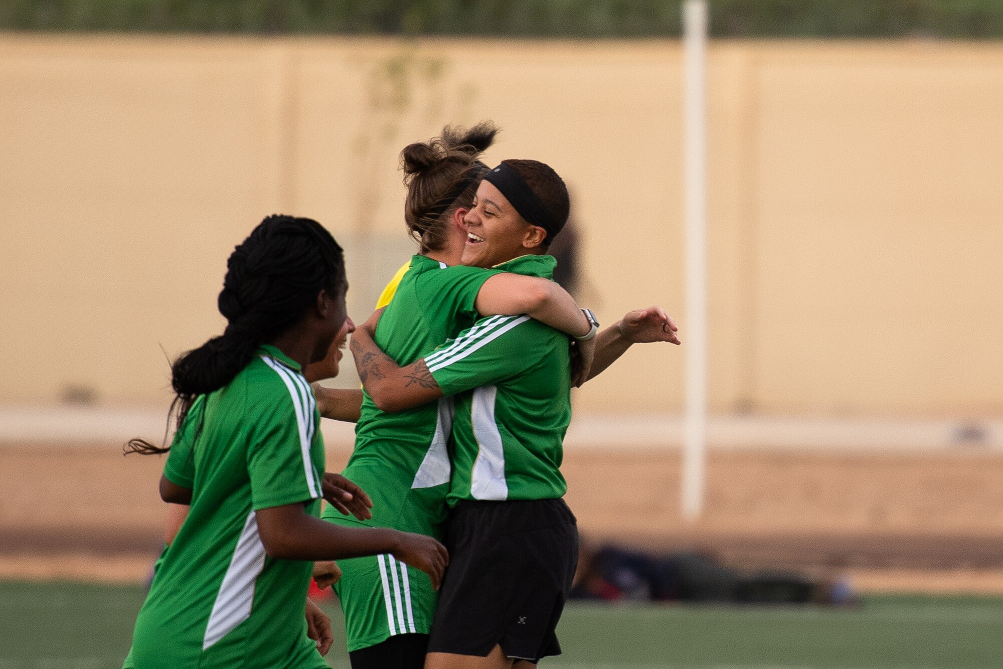 U.S. Air Force Master Sgt. Heather Dragon, 724th Expeditionary Air Base Squadron personnel support for contingency operations member, left, embraces Senior Airman Lexis French, 724th EABS services member, right, after scoring a goal during a recreational game between Nigerien Air Base 201 and the Nassara Athletic Club Women’s Soccer Team at the Agadez Sports Stadium in Agadez, Niger, July 5, 2019. The civil affairs team held the game to build rapport and promote positive sentiment between the local community and AB 201 personnel. (U.S. Air Force photo by Staff Sgt. Devin Boyer)