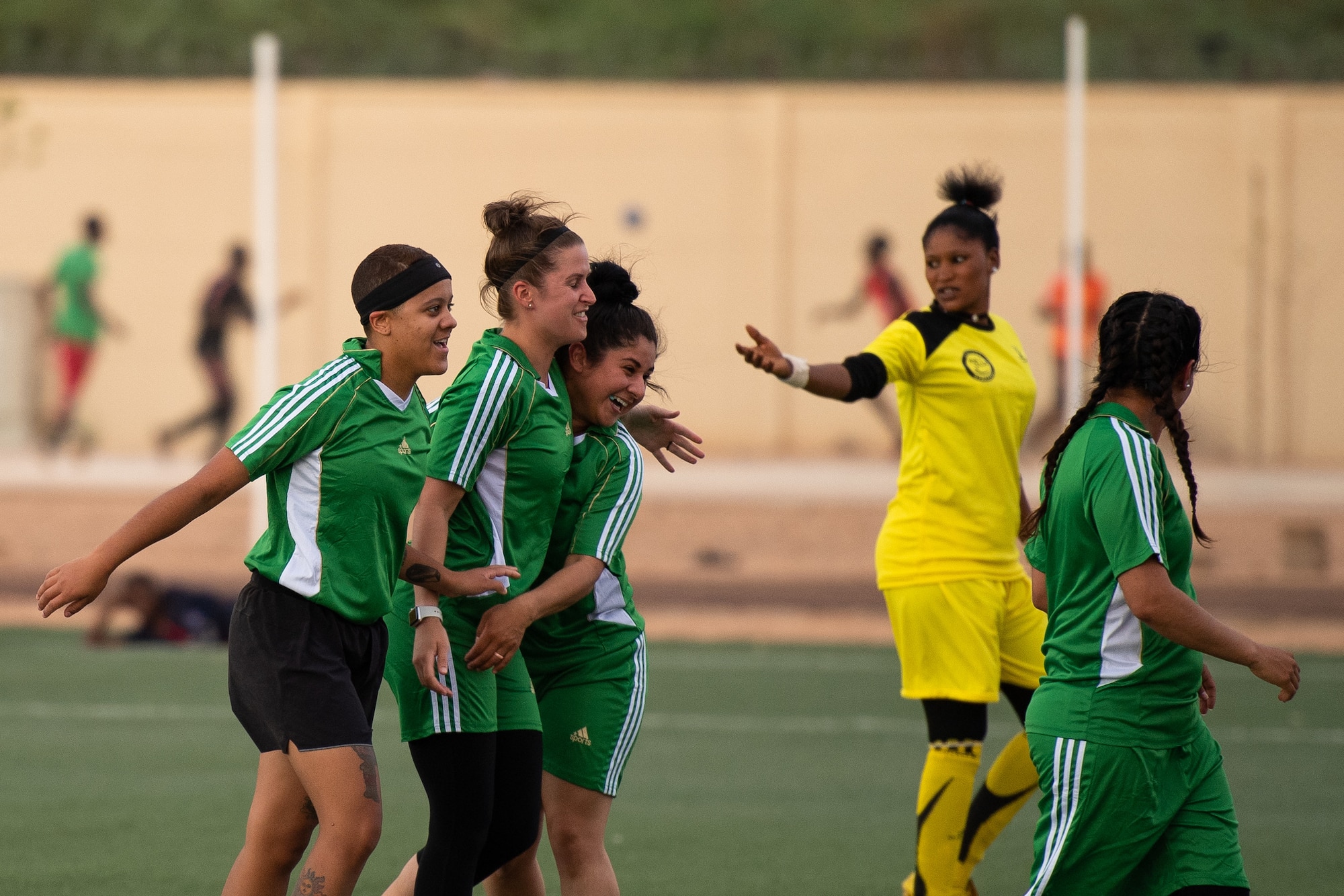 U.S. Air Force Senior Airman Lexis French, 724th Expeditionary Air Base Squadron services member; Master Sgt. Heather Dragon, 724th EABS personnel support for contingency operations member; and Airman 1st Class Alex Ferrero, 724th EABS security forces member, celebrate a goal during a recreational game between Nigerien Air Base 201 and the Nassara Athletic Club Women’s Soccer Team at the Agadez Sports Stadium in Agadez, Niger, July 5, 2019. The civil affairs team held the game to build rapport and promote positive sentiment between the local community and AB 201 personnel. (U.S. Air Force photo by Staff Sgt. Devin Boyer)