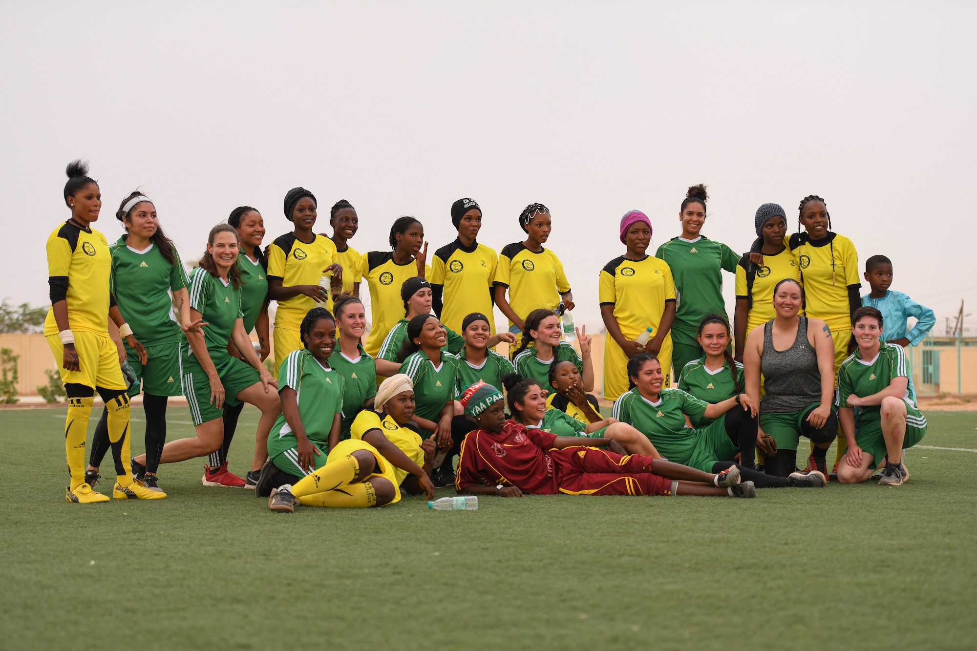 U.S. Air Force women deployed to Nigerien Air Base 201 and the Nassara Athletic Club Women’s Soccer Team pose for a photo after a community outreach game at the Agadez Sports Stadium in Agadez, Niger, July 5, 2019. The civil affairs team organized the event that also included the donation of soccer balls to the women’s team and youth development team. (U.S. Air Force photo by Senior Airman Lexie West)