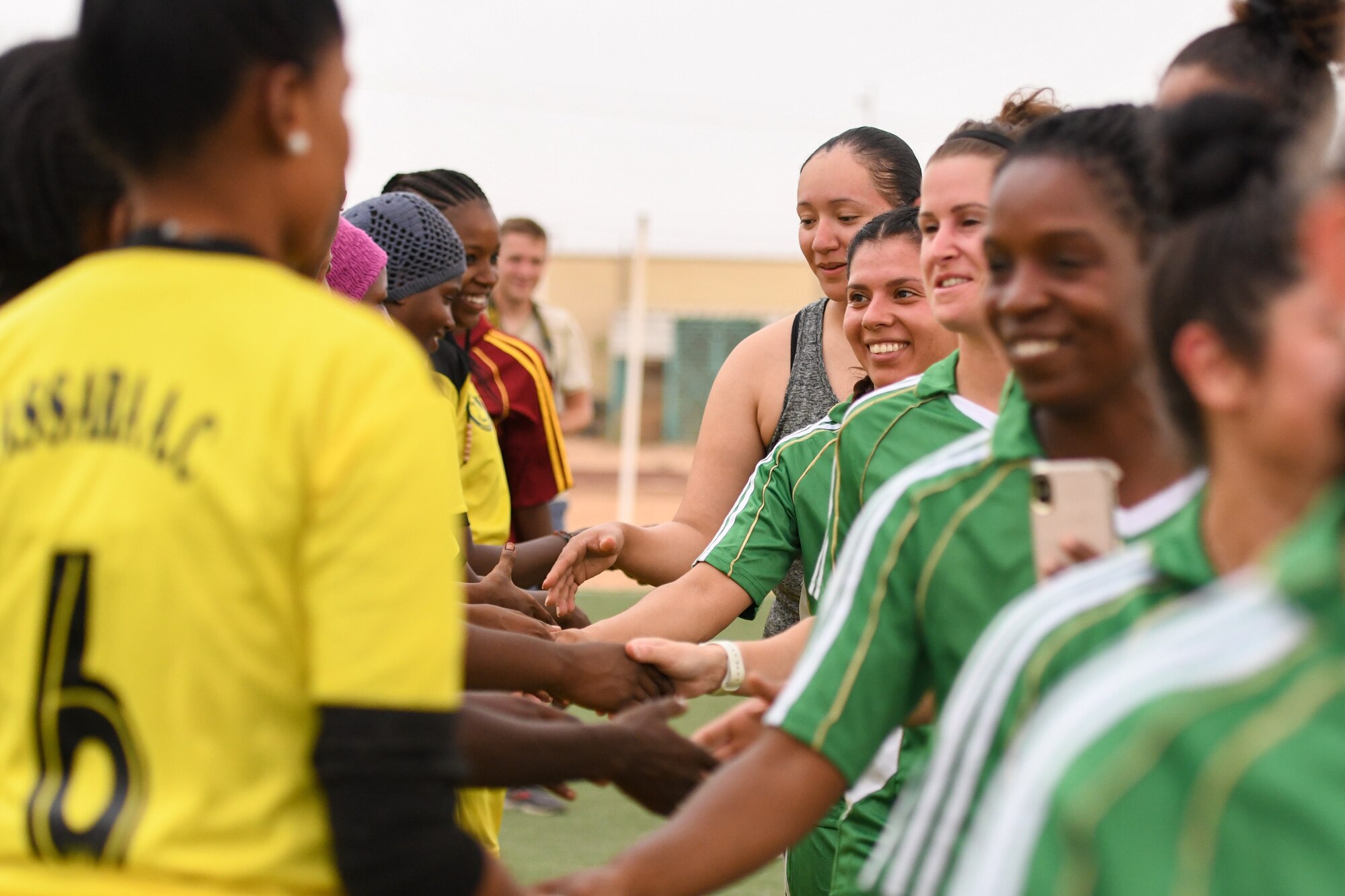 U.S. Air Force women deployed to Nigerien Air Base 201 and the Nassara Athletic Club Women’s Soccer Team shake hands after a community outreach game at the Agadez Sports Stadium in Agadez, Niger, July 5, 2019. The civil affairs team held the game to build rapport and promote positive sentiment between the local community and AB 201 personnel. (U.S. Air Force photo by Senior Airman Lexie West)