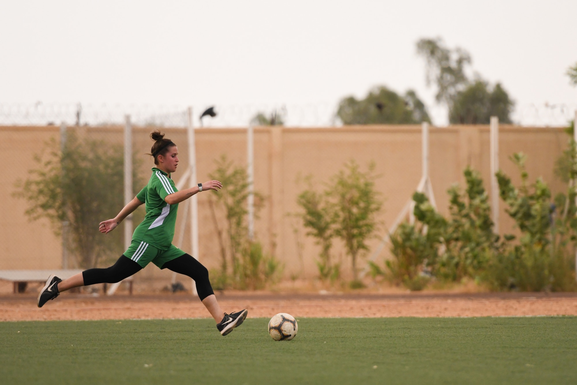 U.S. Air Force Master Sgt. Heather Dragon, 724th Expeditionary Air Base Squadron personnel support for contingency operations member, prepares to strike a soccer ball in a game against the Nassara Athletic Club Women’s Soccer Team at the Agadez Sports Stadium in Agadez, Niger, July 5, 2019. The civil affairs team organized the community outreach event that also included the donation of soccer balls to the women’s team and youth development team.  (U.S. Air Force photo by Senior Airman Lexie West)