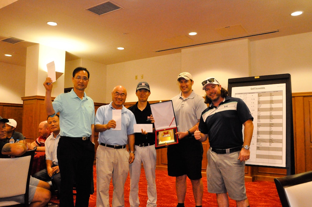 Ross Moore (right), a physical security specialist, stands along with the U.S. Army Corps of Engineers, Far East District, Bi-Annual Golf Tournament winners at the River Bend Golf Course, Camp Humphreys, South Korea, June 26.