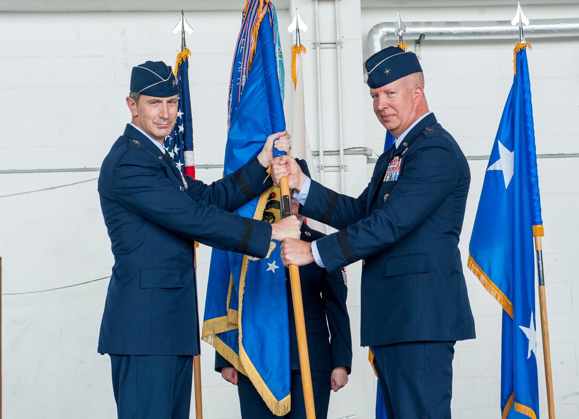 U.S. Air Force Lt. Gen. Kevin Schneider, U.S. Forces Japan and 5th Air Force commander, passes the 18th Wing guidon to Brig. Gen. Joel Carey, incoming 18th Wing commander, during a change of command ceremony July 8, 2019, at Kadena Air Base, Japan.
