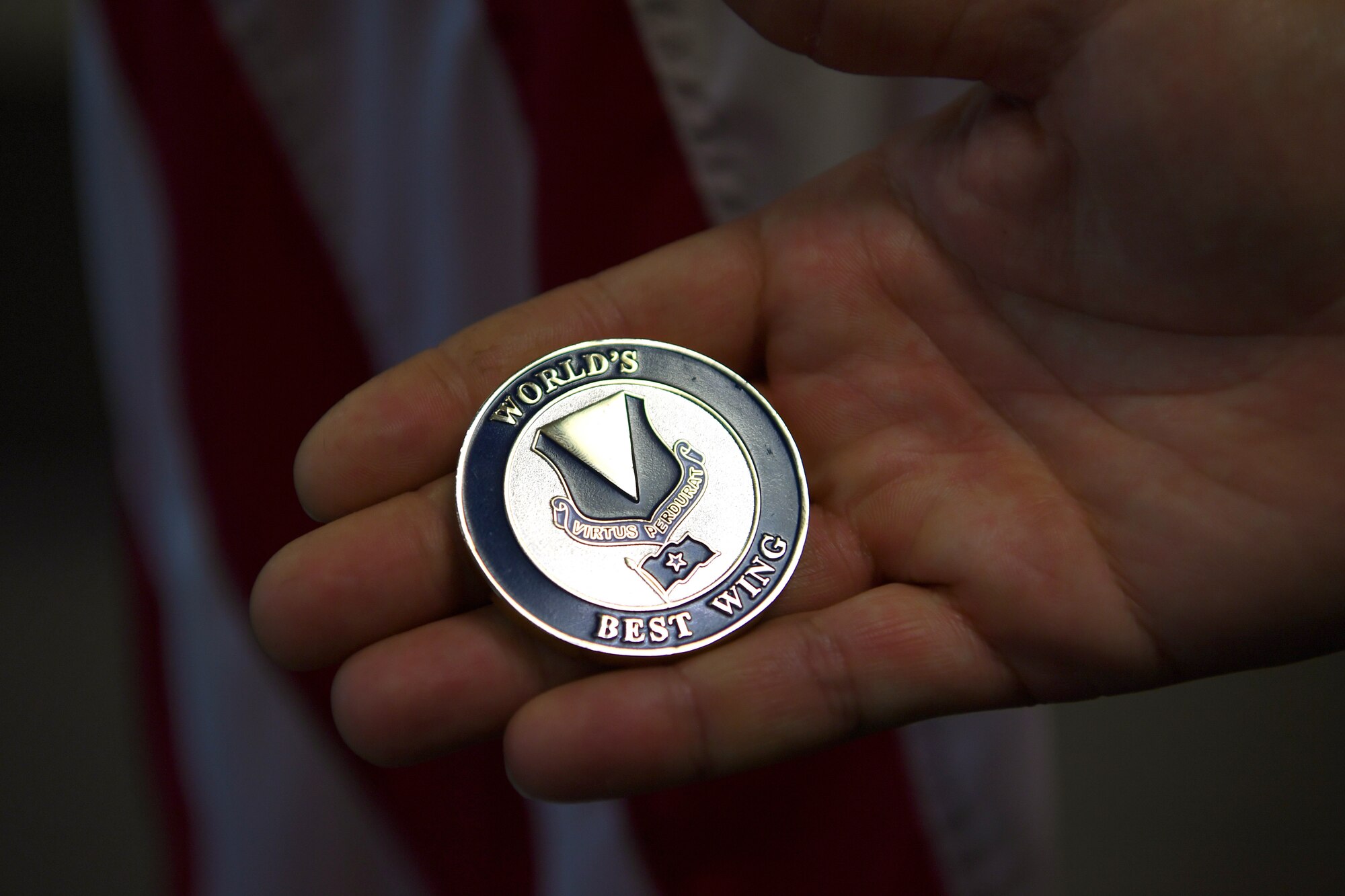 U.S. Air Force Staff Sgt. Wayne PhillipS, 76th Airlift Squadron flight attendant, holds his 86th Airlift Wing commander’s coin at the 76th Airlift Squadron headquarters building on Ramstein Air Base, Germany, June 27, 2019.