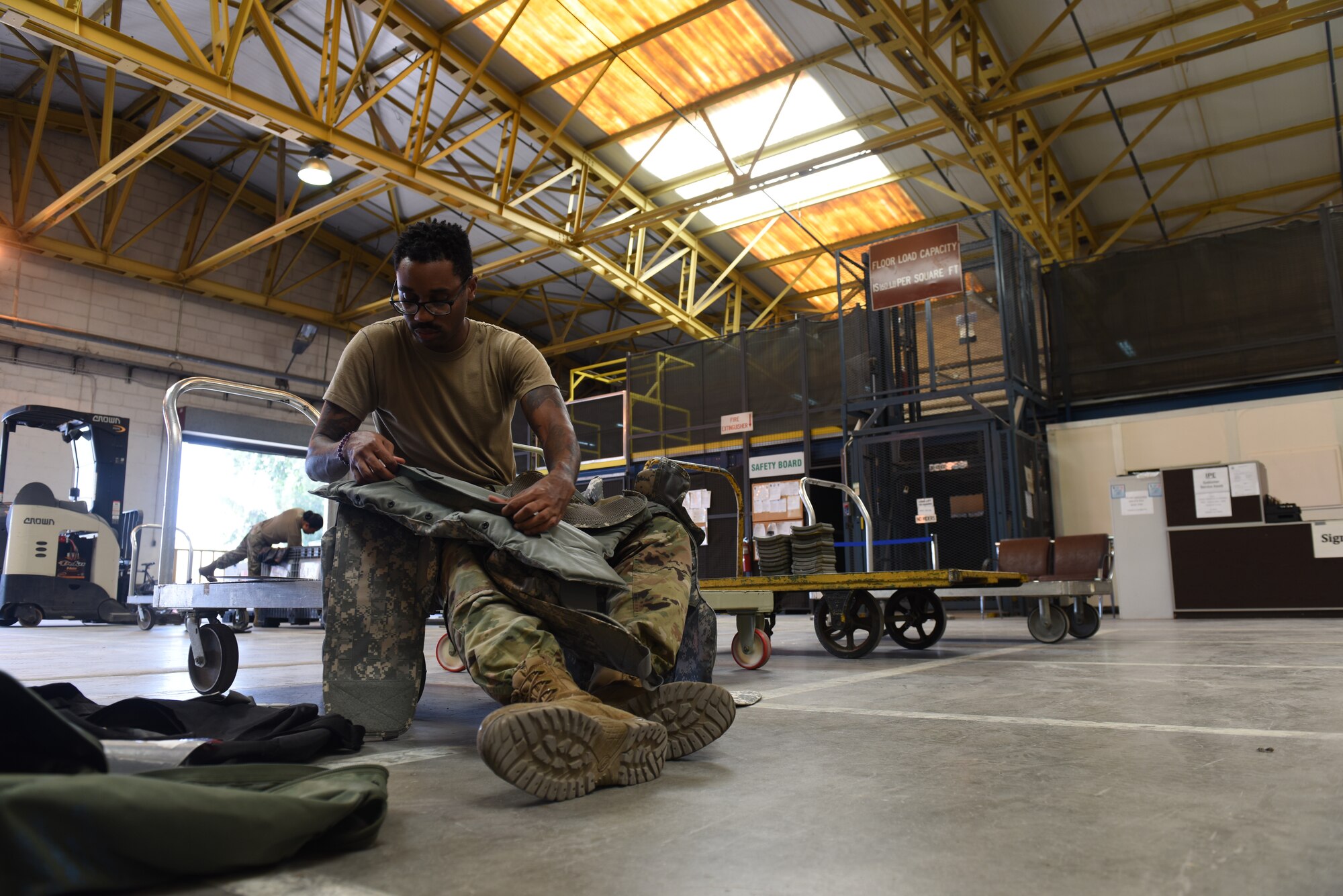 Photo of Staff Sgt. Tommie Hudson inspecting body armor.