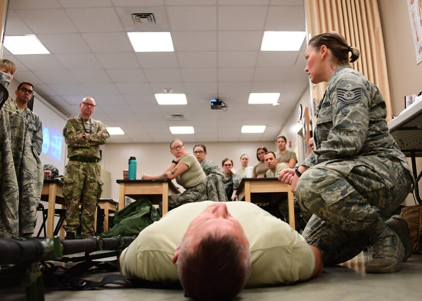 Tech Sgt. Nicole Martin, aerospace medical technician with the 911th Aeromedical Staging Squadron, trains members of the 911th Airlift Wing and the Royal Air Force Leuchars, Scotland, on the proper way to get a patient onto a litter at Fort Indiantown Gap, Pennsylvania, June 19, 2019. Martin showed the Airmen that when putting a patient onto a litter it is important to make sure that a blanket be put under them in order to prevent hypothermia and protect their wounds from the elements as they are transported. (U.S. Air Force photo by Senior Airman Grace Thomson)