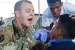 A dentist examines a patient.