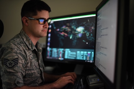 U.S. Air Force Staff Sgt. Caleb uses a computer programs to identify network issues during his unit's training period at Berry Field Air National Guard Base, Nashville, Tenn, on May 5, 2019. Caleb's unit was  training in advanced network systems and resolving network issues. (This photo has been altered for security purposes by blurring out identification badges.)