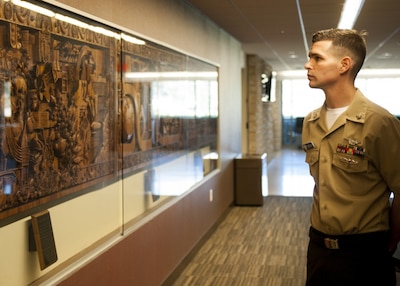 Military man looking at historical wall