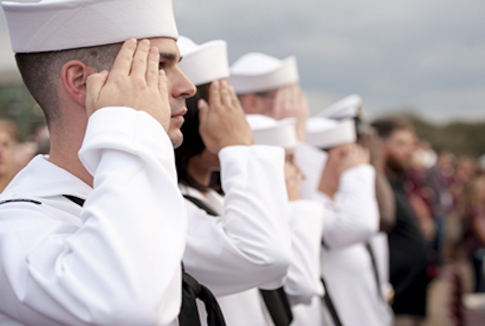 Sailors in white uniform in line saluting
