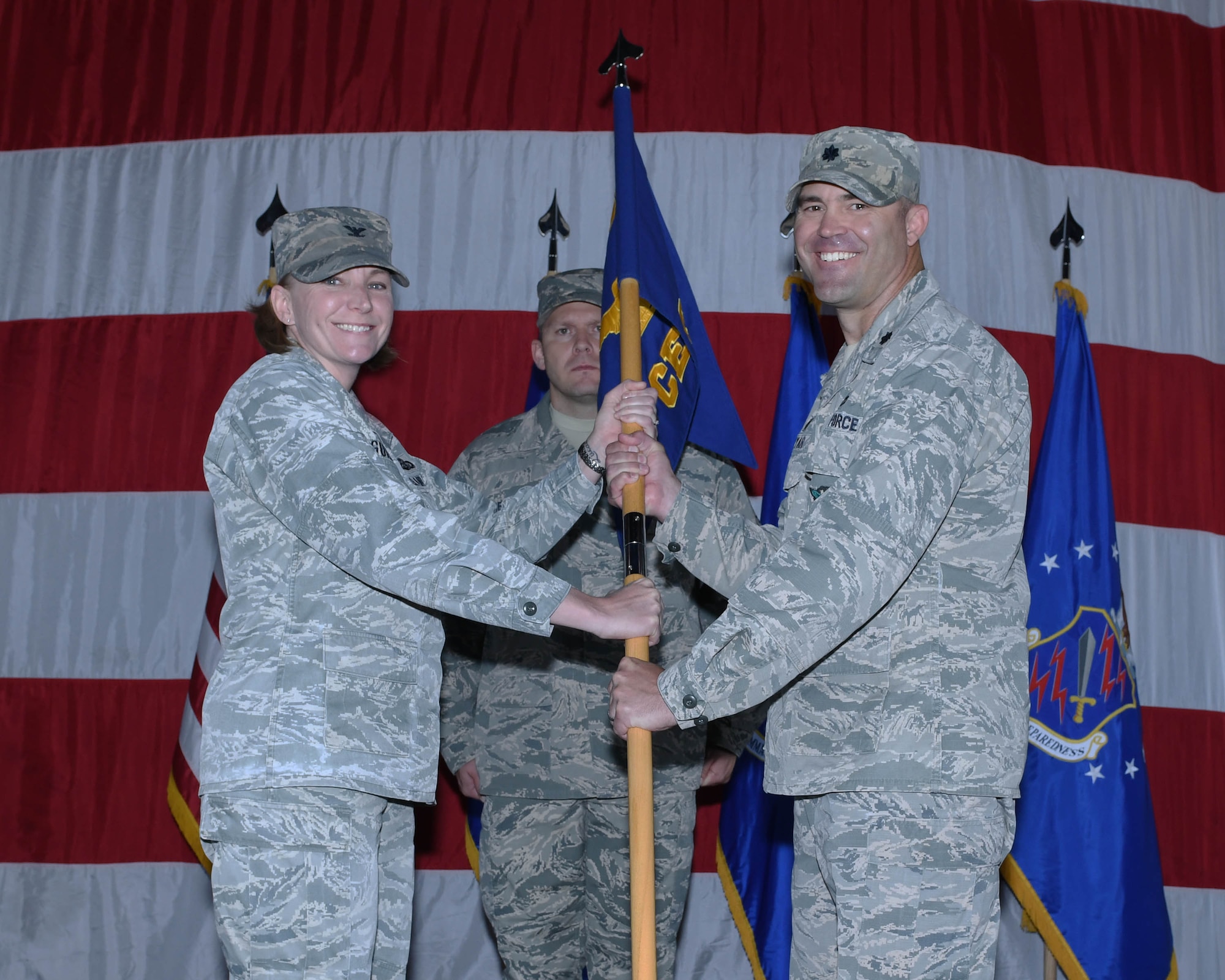 PETERSON AIR FORCE BASE, Colo. – Col. Kirsten Aguilar (left), 21st Mission Support Group commander, presents the guidon to Lt. Col. Timothy Fryar (right), the new 21st Civil Engineer Squadron commander, during a change of command ceremony June 27, 2019 at Peterson Air Force Base, Colorado. The passing of the guidon represents a formal transfer of authority and responsibility from an outgoing commander to an incoming one, ensuring that the unit and its Airmen are never without leadership. (U.S. Air Force photo by Airman 1st Class Andrew J. Bertain)
