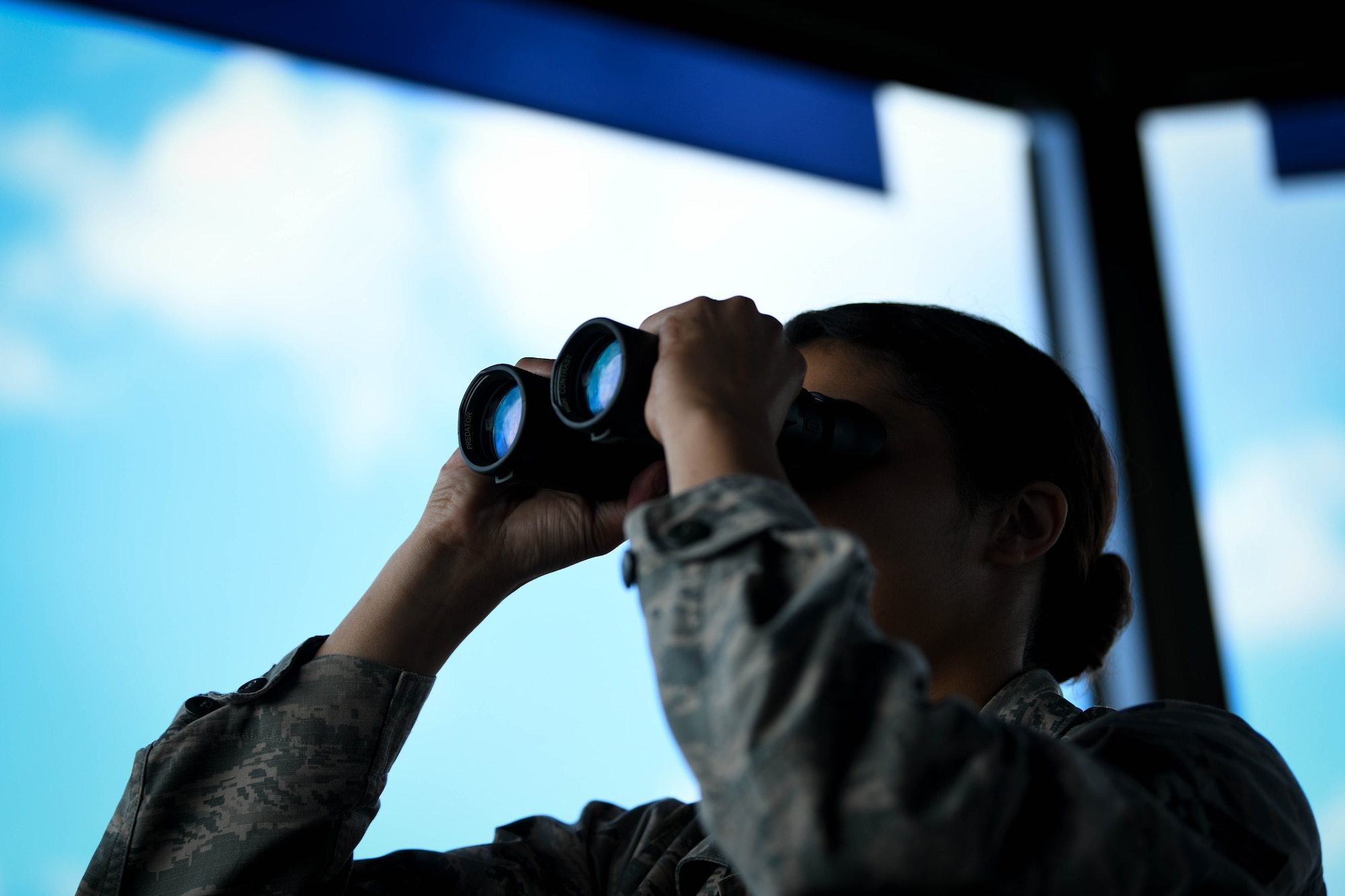 Senior Airman Bailey Hairston, 375th Operational Support Squadron air traffic controller, uses binoculars to look for birds or other hazards that can damage aircraft