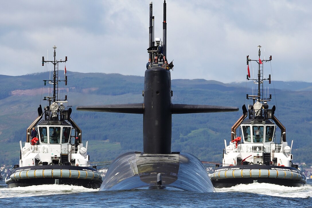 A submarine travels through waters surrounded by two boats.