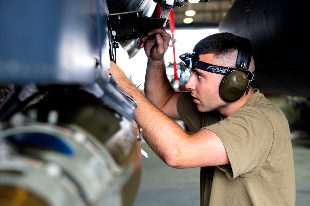 An airman looks through an airplane panel.