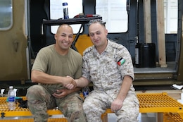 U.S. Army Staff Sgt. Jose Medina, 1106th Aviation Group, and 2nd Lt. Fareed Hailat, Royal Jordanian Air Force, shake hands during a recent UH-60 Blackhawk helicopter subject matter expert exchange at the King Abdullah II Air Base in Amman, Jordan, June 19, 2019.