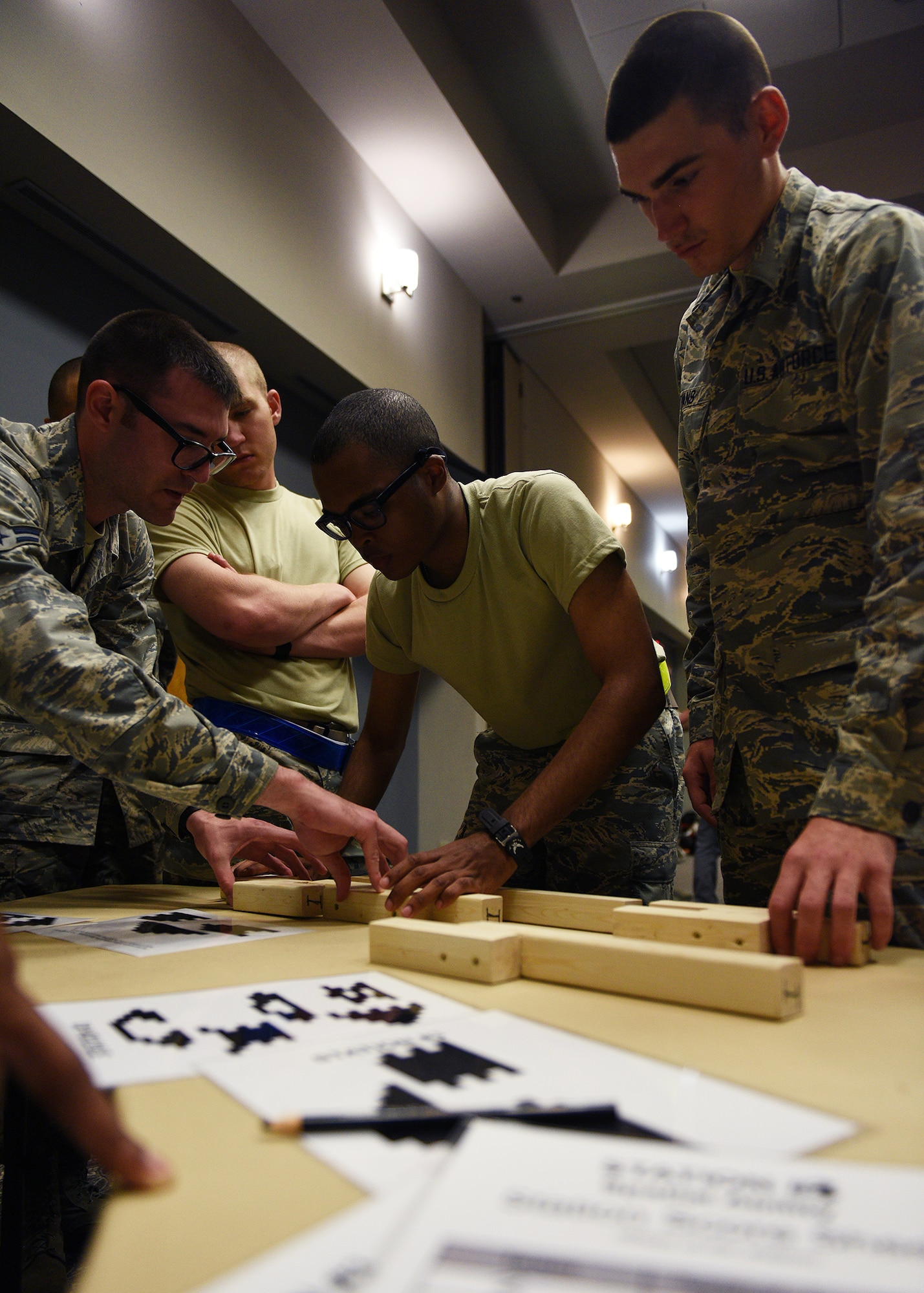 Participants of the Mental Fitness Obstacle Course work to complete a puzzle within the required time limit in conjunction with various callisthenic exercises at the event center on Goodfellow Air Force Base, Texas, July 2, 2019. The course was designed by the 17th Training Group to highlight the link between physical exertion and cognitive tasks for new technical training students. (U.S. Air Force photo by Staff Sgt. Chad Warren/Released)