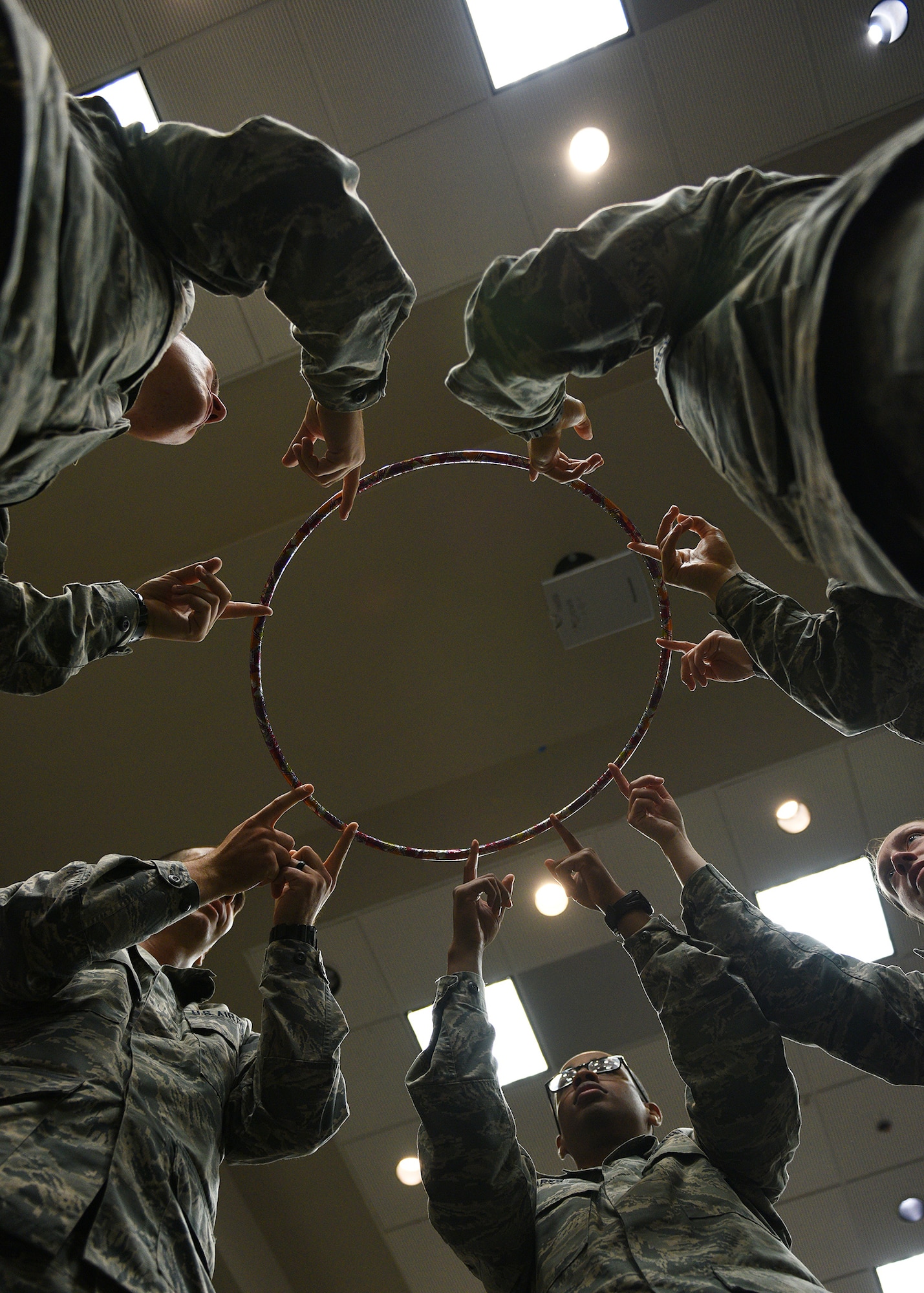 Five technical training students attempt to complete a teamwork exercise during the Mental Fitness Obstacle Course at the event center on Goodfellow Air Force Base, Texas, July 2, 2019. The course consisted of groups of students performing strenuous physical activity followed by performing cognitive and mental skills to highlight the link between physical and mental fitness. (U.S. Air Force photo by Staff Sgt. Chad Warren/Released)