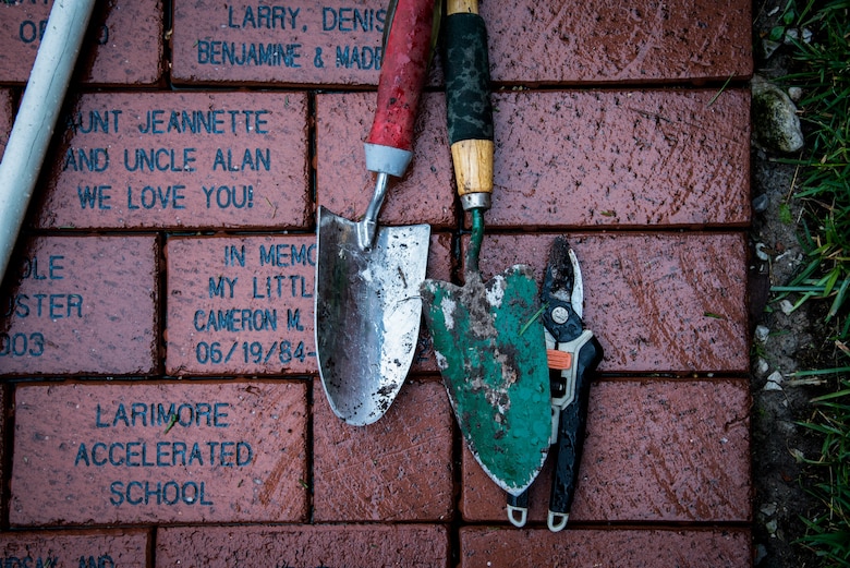 Tools used by volunteers rest on bricks with messages from families who have stayed at the Ronald McDonald house in St. Louis