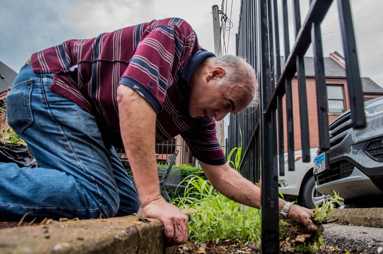 Nick Sipos, 618th Air Operations Center deputy director, picks weeds at a Ronald McDonald House in St Louis