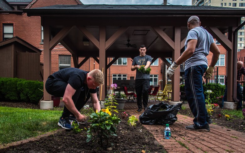 Airmen from Scott Air Force Base clean up a flower bed at the Ronald McDonald House in St. Louis