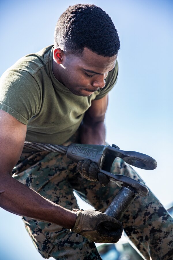 U.S. Marine Corps Lance Cpl. Tyre Reynolds, a motor vehicle operator with Marine Wing Support Squadron (MWSS) 372, Marine Wing Support Group (MWSG) 37, 3rd Marine Aircraft Wing (MAW), removes a winch from a trailer during a Logistics Vehicle System Replacement (LVSR) MKR-16 tractor and M870A2 trailer licensing course at the 25 area motor pool, Marine Corps Base Camp Pendleton, California, July 2, 2019. MWSS-372 is responsible for providing vehicular transportation and support to the various units housed at Marine Corps Air Station Camp Pendleton. (U.S. Marine Corps photo by Cpl. Dylan Chagnon)