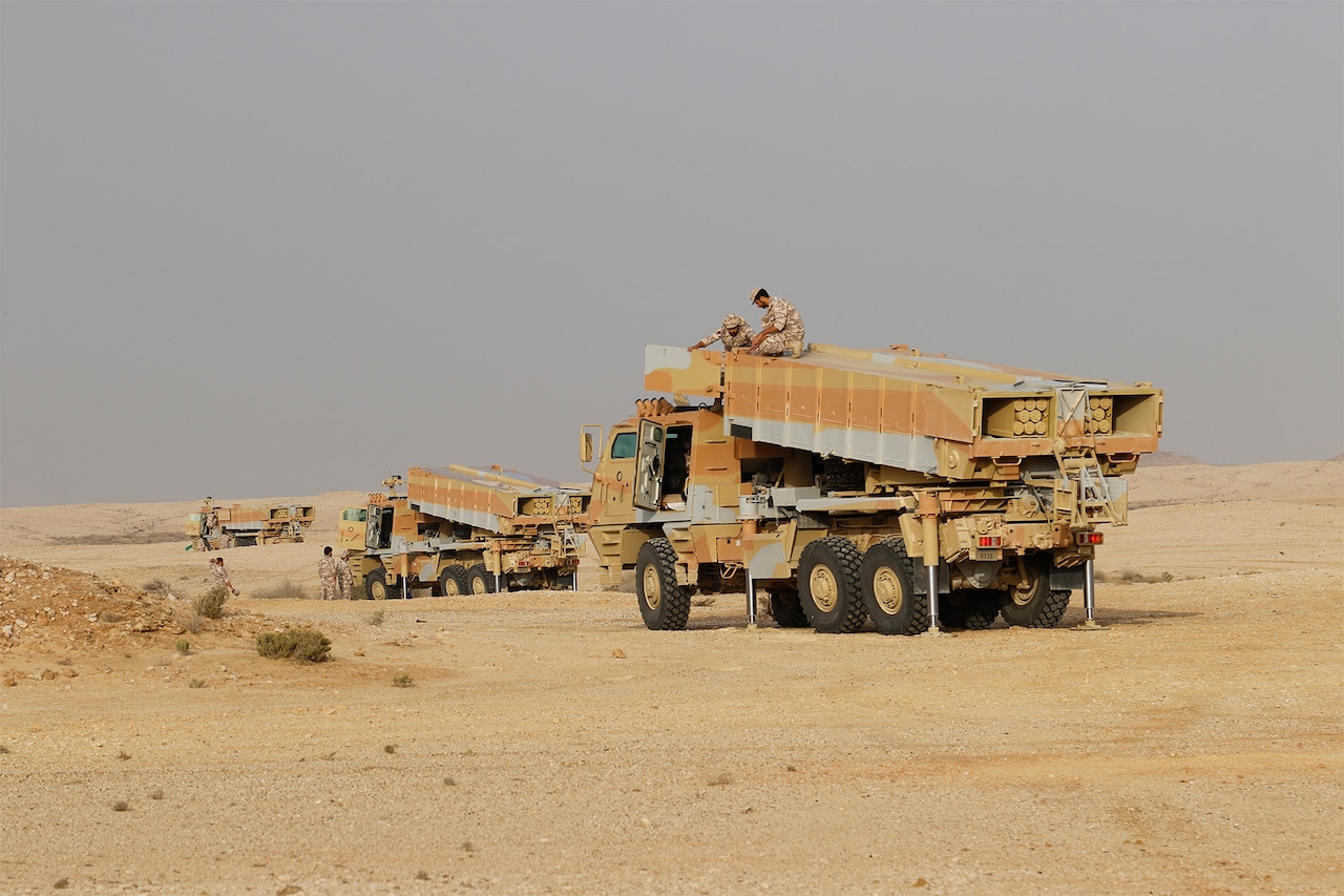 Soldiers atop large vehicles.