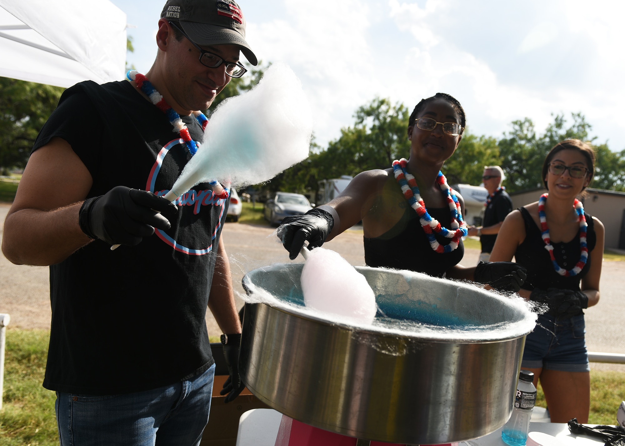 Members of the First Four Council make cotton candy during the Independence Day celebration at the Goodfellow Recreation Camp, Texas, July 4, 2019. Several base organizations volunteered their time to provide food and entertainment to Goodfellow members and their families. (U.S. Air Force photo by Staff Sgt. Chad Warren/Released)
