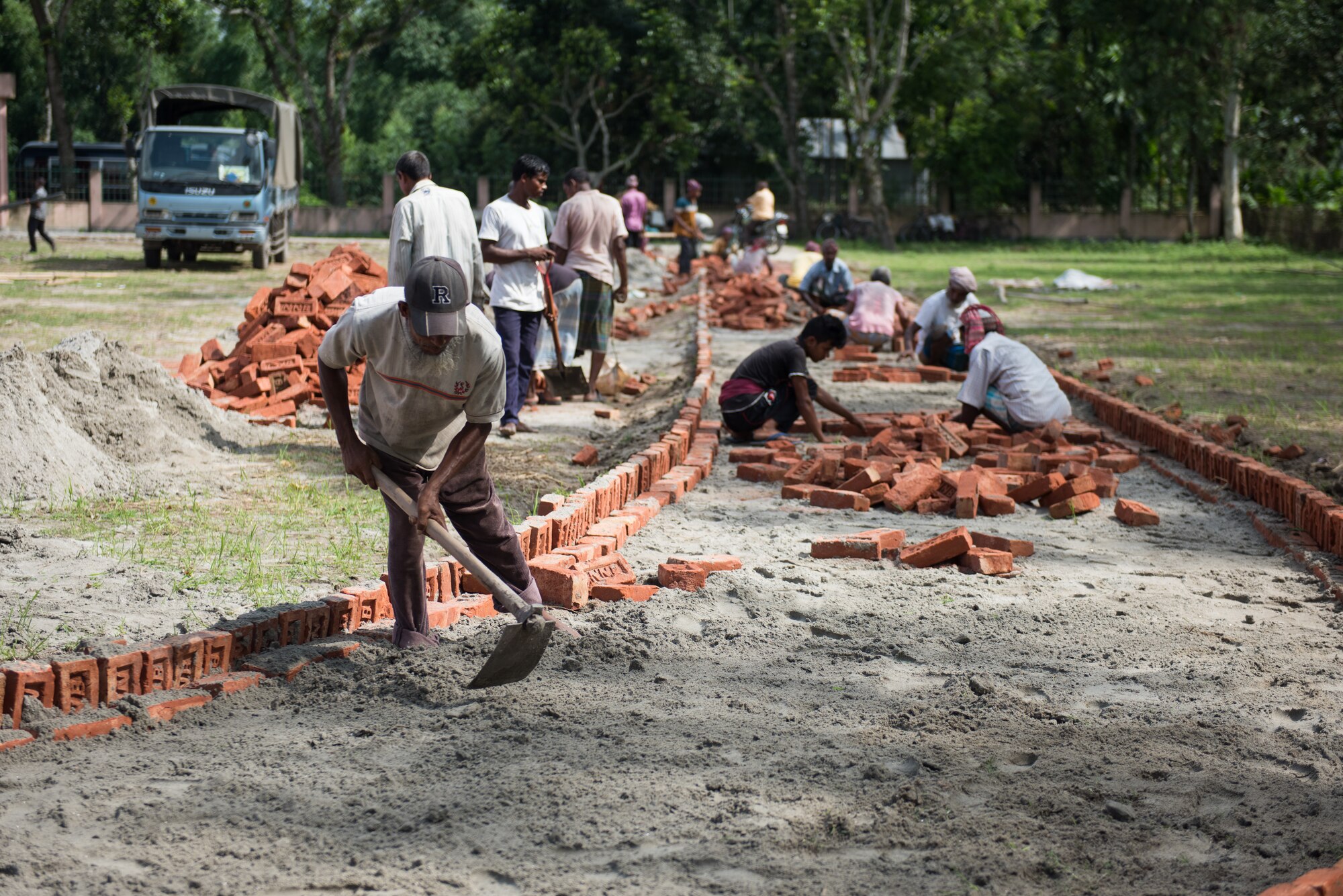 Bangladeshi workers construct a pathway leading to the medical clinic for Pacific Angel 19-1 in Lalmonirhat, Bangladesh, June 22, 2019. Pacific Angel 2019 is a joint and combined humanitarian assistance engagement, enhancing participating nations’ humanitarian assistance and disaster relief capabilities while providing beneficial services to people in need throughout South Asia. (U.S. Air Force photo by Staff Sgt. Ramon A. Adelan)