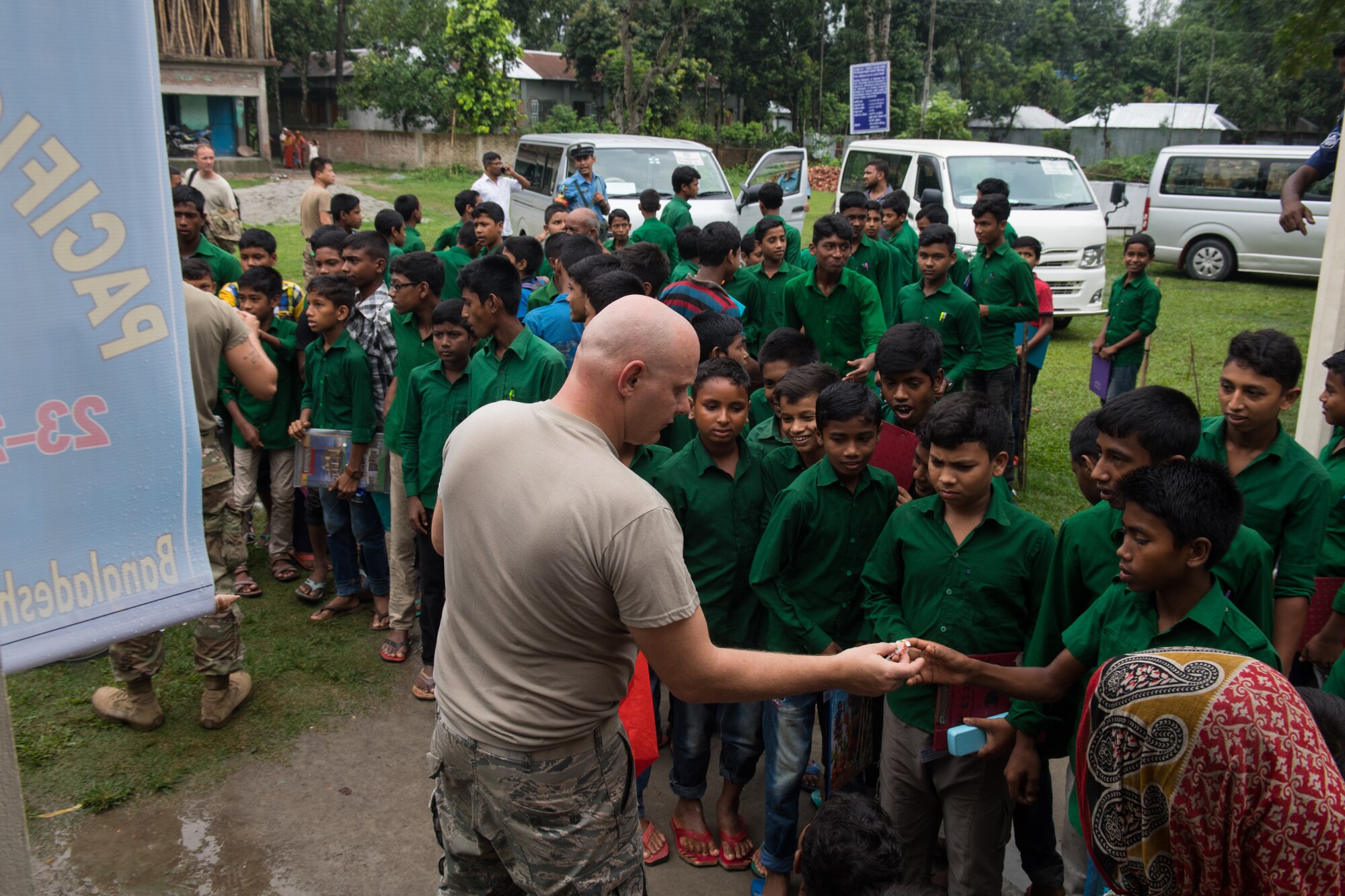 U.S. Air Force Staff Sgt. Danny Mclain, 18th Civil Engineer Squadron structural craftsman, Kadena Air Base, Japan, hands out candy to students during Pacific Angel 19-1 in Lalmonirhat, Bangladesh, June 25, 2019. These humanitarian assistance exercises build relationships between Bangladesh, the United States, and other regional nations, promoting military-civilian-nongovernmental organization cooperation. (U.S. Air Force photo by Staff Sgt. Ramon A. Adelan)