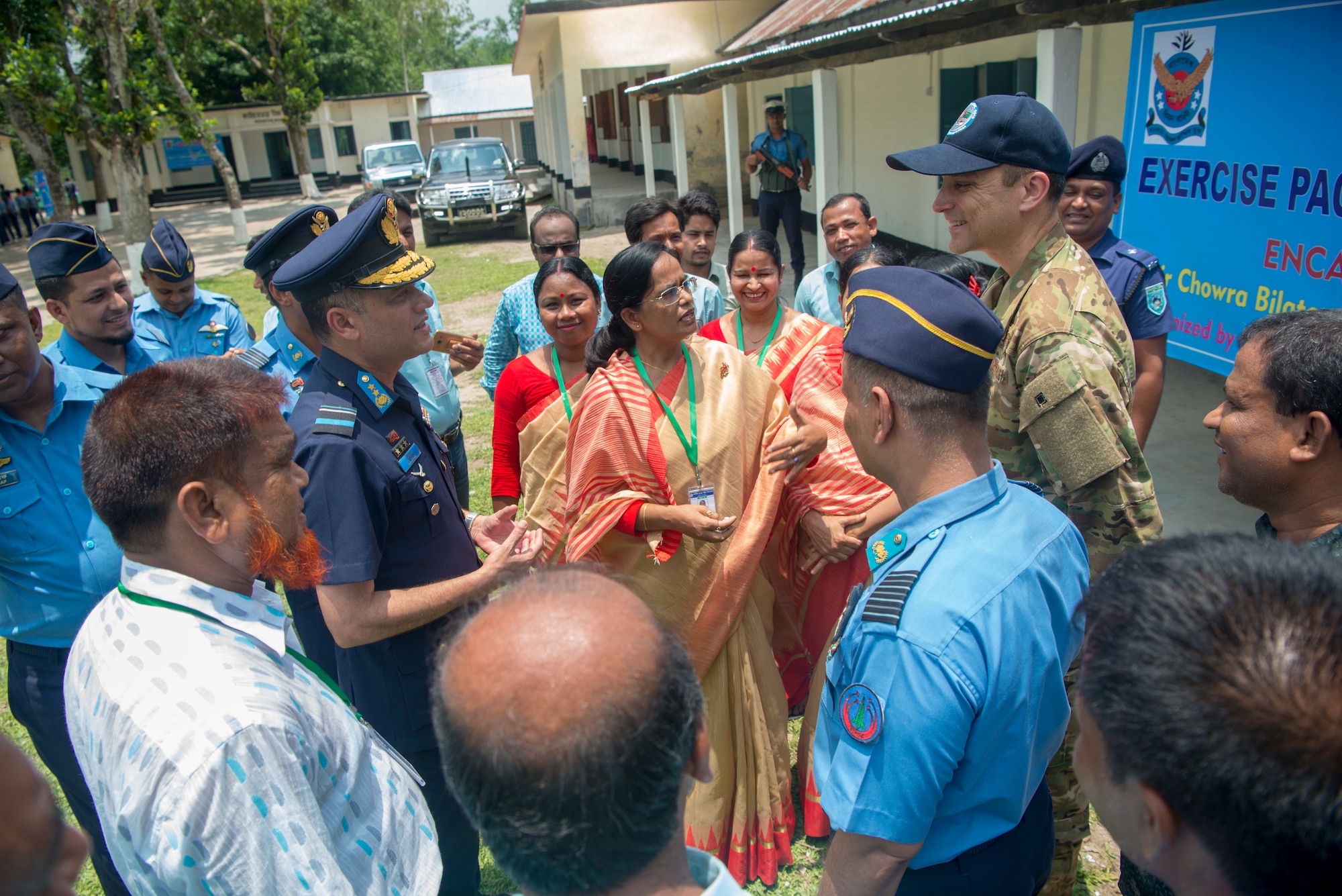 Bangladesh Air Force Maj. Gen. M. Nazoul Islam, center left, commanding officer of BAF Base Matiur Rahman, and U.S. Air Force Maj. Kristoffer Palmer, center right, Pacific Angel 19-1 mission commander, speak with teachers after celebrating the opening ceremony of Pacific Angel 19-1 at Kazir Chowra Bilateral High School in Lalmonirhat, Bangladesh, June 23, 2019. Pacific Angel 2019 is a joint and combined humanitarian assistance engagement, enhancing participating nations’ humanitarian assistance and disaster relief capabilities while providing beneficial services to people in need throughout South and Southeast Asia. (U.S. Air Force photo by 2nd Lt. Brigitte N. Brantley)