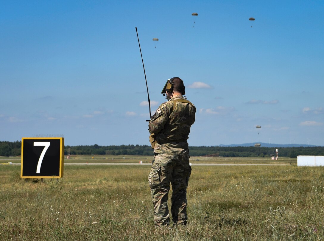 U.S. Air Force Tech. Sgt Joshua Todd, 435th Contingency Response Squadron drop zone controller, monitors parachutists during personnel drops over Ramstein Air Base, Germany, July 2, 2019. The 435th CRG conducts approximately 24 training jumps annually, allowing personnel to maintain proficiency and readiness.