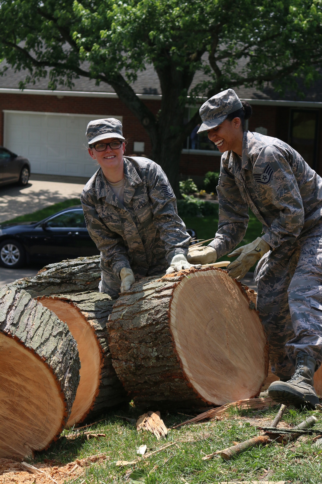 Tech. Sgt. Aubrey Booher (left) and Staff Sgt. Adrienne Zizza, both from the 445th Aerospace Medicine Squadron, remove trees from the home a 445th Airman, June 2, 2019.