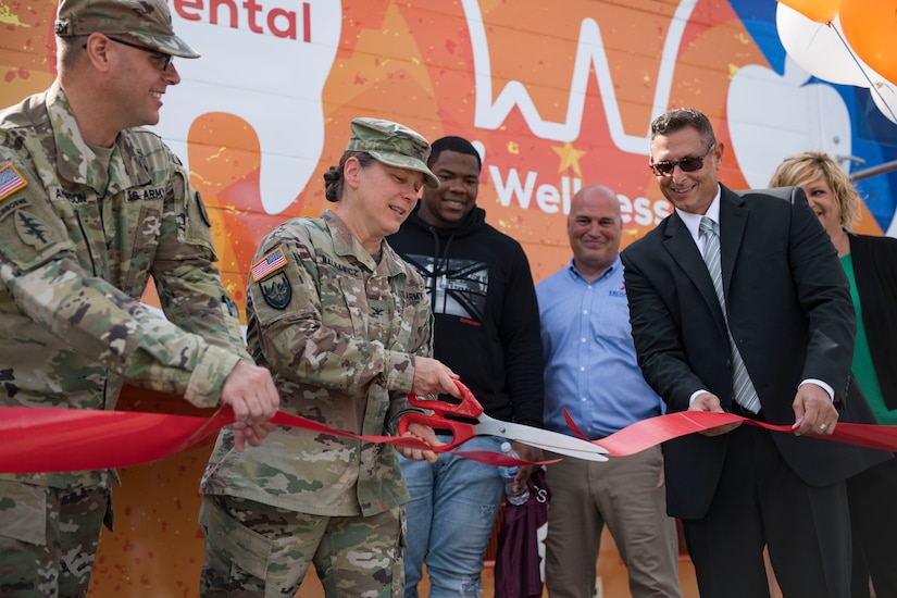 U.S. Army Col. Jennifer S. Walkawicz, 733rd Mission Support Group commander, cuts a ribbon during the grand opening of the Dentrust Optimized Care Solutions mobile treatment facility at Joint Base Langley-Eustis, Virginia, July 8, 2019.