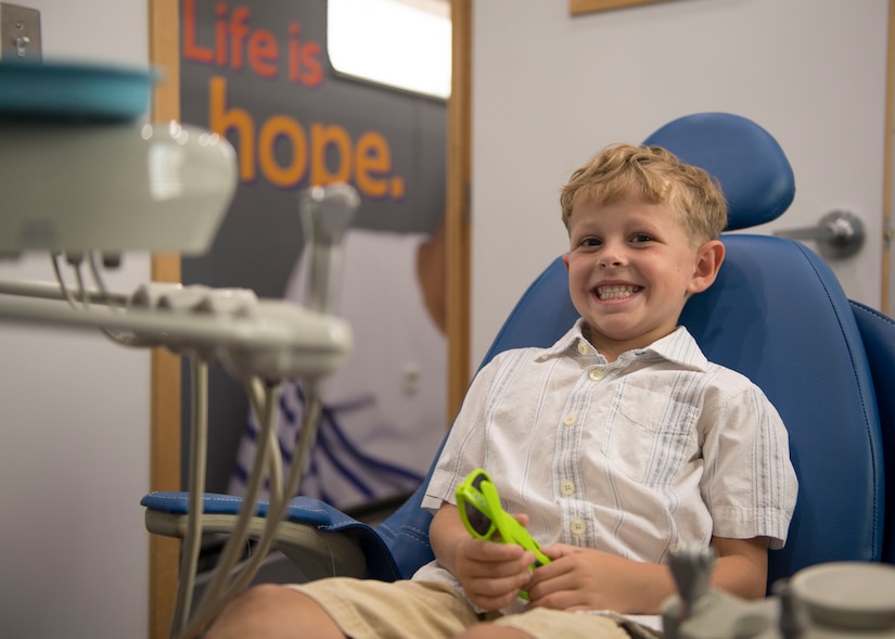 Caden, 5, son of Amara Camarata, Dentrust Optimized Care Solutions office manager, sits in a dental chair during the grand opening of the DOCS mobile treatment facility at Joint Base Langley-Eustis, Virginia, July 8, 2019.